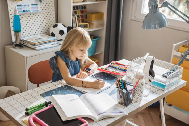 istock Schoolgirl studying at home 1647107514