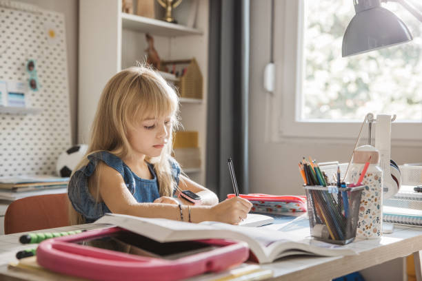 istock Schoolgirl studying at home 1647107978