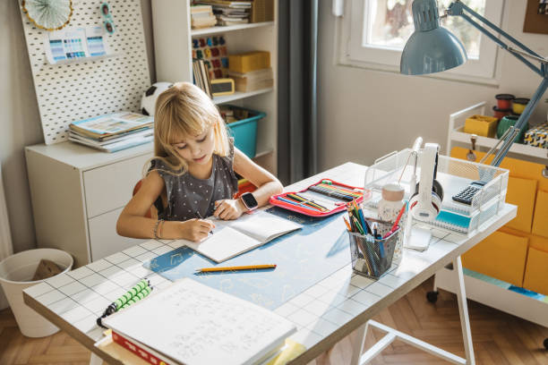 istock Schoolgirl studying at home 1647108058