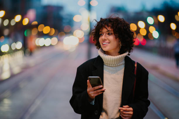 istock Dark haired woman looking aside with a smile while walking down the streets. 1647136339