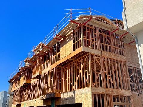 View of new wood frame construction of new housing with blue sky in Southern California