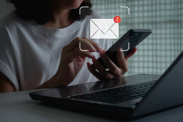 istock Email inbox serves alert notifications for internet security, guarding against spam, viruses, compromised data. Cautionary measures ensure protection from junk and trash mail. Woman using smartphone. 1647155766