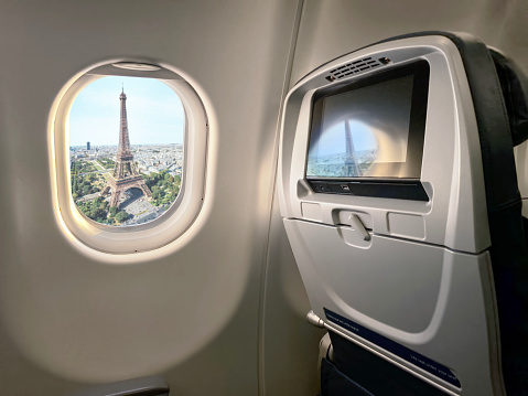Wide angle shot of an airplane cabin with Eiffel tower view in from window