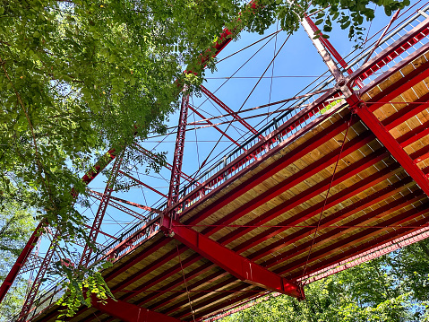 This red bridge is one of the five restored bridges situated in Historic Bridge Park in Battle Creek, Michigan. This is a museum of transportation history that you can walk through on pedestrian trails in this park along the Kalamazoo River.