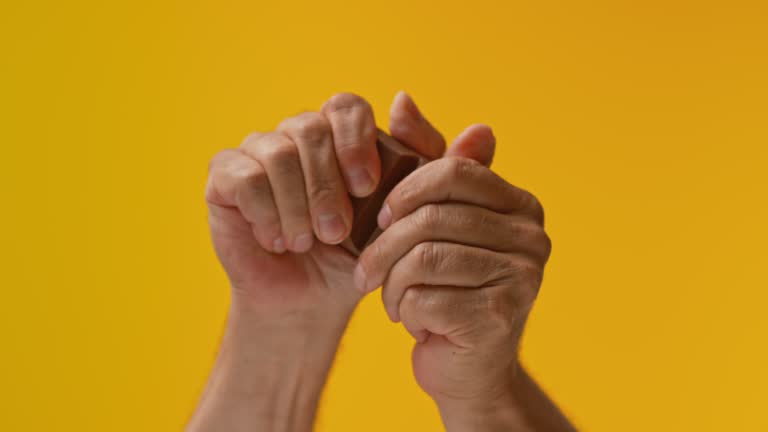 SLO MO LD Hands trying to break a chocolate bar