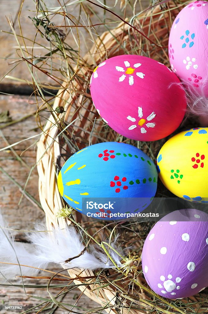 Nido di uova di Pasqua colorate su sfondo in legno - Foto stock royalty-free di Colore brillante