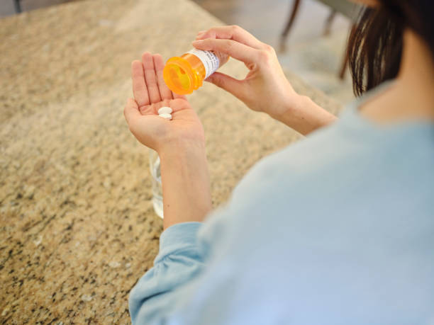 istock Woman Taking Medication in a Home Kitchen 1647339745