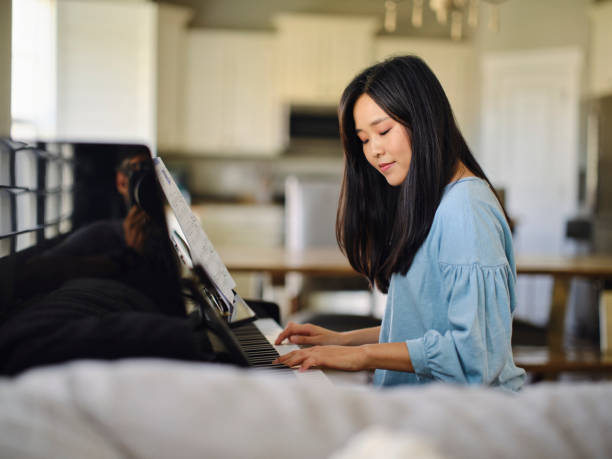 istock Adult Woman Practicing Piano in a Home 1647343029