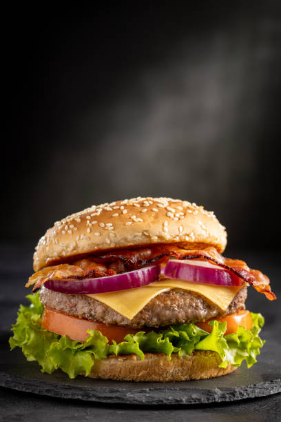 istock Delicious hamburger with meat, cheese, bacon and salad. 1647346637
