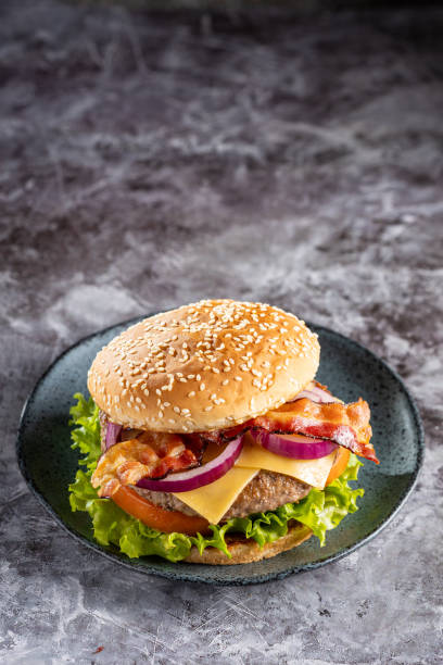 istock Delicious hamburger with meat, cheese, bacon and salad. 1647348699