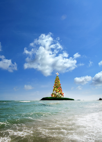 Conceptual decorated shiny Christmas tree in tropical landscape at Koh Samui island, Thailand