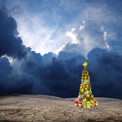 Conceptual decorated shiny Christmas tree in barren land