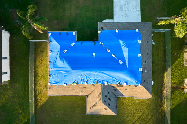 istock Hurricane Ian damaged house rooftop covered with protective plastic tarp against rain water leaking until replacement of asphalt shingles. Aftermath of natural disaster 1647371984