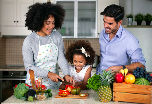 Happy young multiethnicity family in the kitchen.
