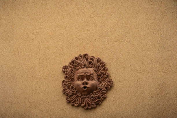 Renaissance classical stone carving of an old mans head with beard in shadow on a wall in venice italy