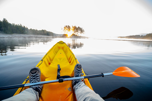 Paddling and eco tourism. Rowing in a calm water at sunrise. Connecting with nature.
