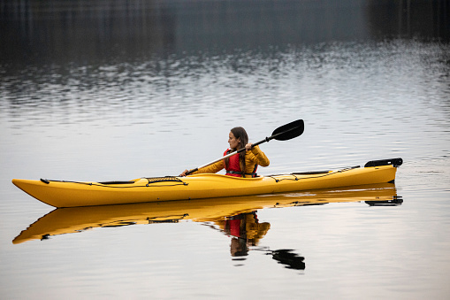 Kayaking and eco tourism. Woman connecting with nature. Exercise and body training.