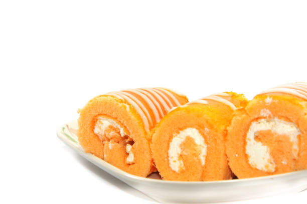 Orange Jam Roll Cake is a snack with Tea or coffee on a white background. Use lights and flash for clarity.