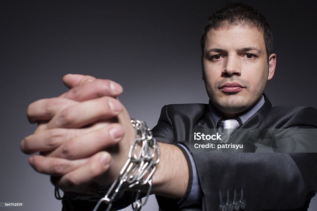 Businessman Struggles Against Chains Businessman Struggles Against Chain Adult Stock Photo