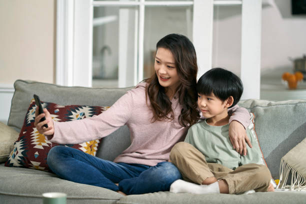 istock asian mother and son taking a selfie together at home using cellphone 1647448304