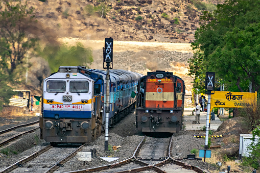 Daundaj, Maharashtra, India-June 3rd, 2017: One passenger train with EMD locomotive, overtakes another with ALCo locomotive at station.