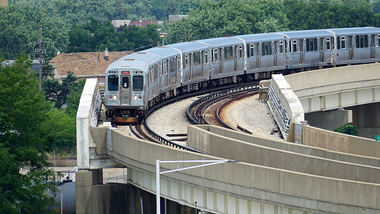 Chicago, IL, USA - August 2 2023: CTA Orange Line train rounds a corner as it approaches Chicago Midway International Airport.