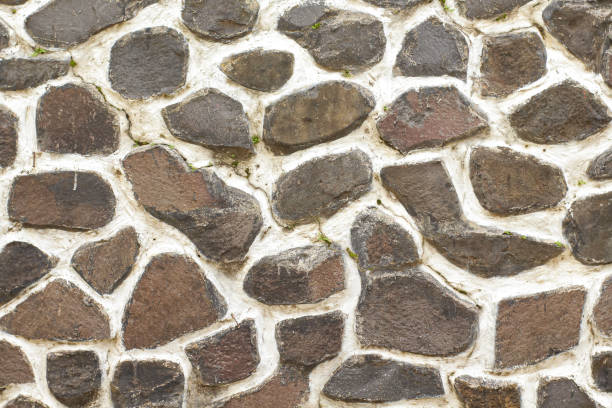 istock a wall made of large boulders and covered with thick cement 1647492701