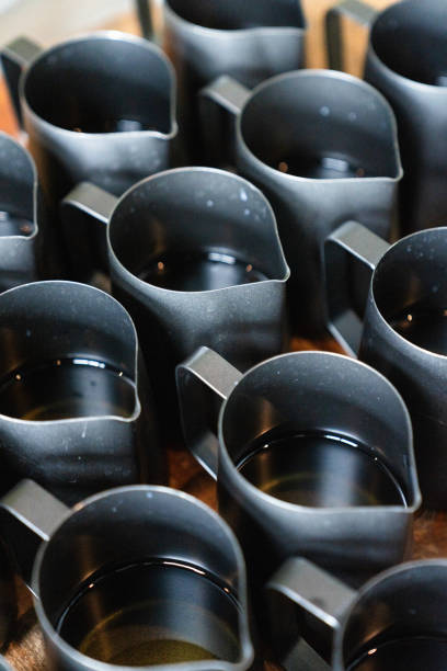Melted candle wax sitting in black pour jars