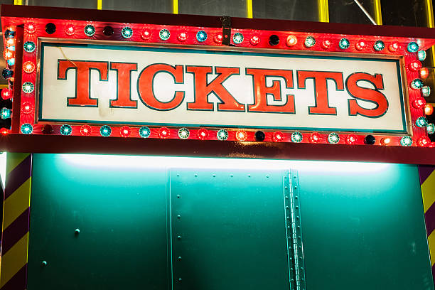 A ticket booth lights the midway at night at a fair