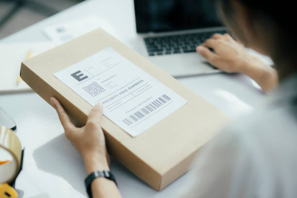 istock Young business owner putting shipping label on parcel. 1647521262