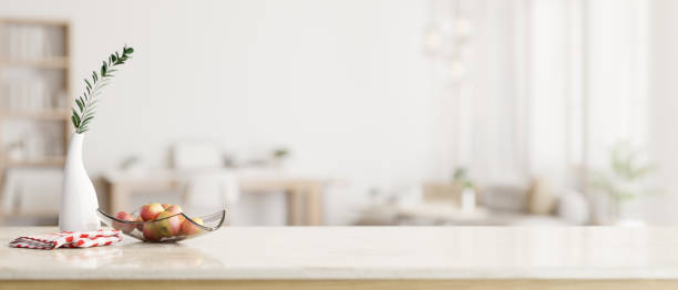 istock Copy space on a white tabletop with a blurred modern white living room in the background. 1647550476