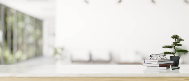 istock Copy space on a white tabletop with a blurred modern white office corridor in the background 1647550477