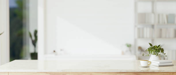istock Copy space on a white tabletop with a blurred modern white room in the background. 1647550480