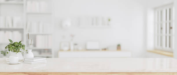 istock Copy space on a white tabletop with a blurred modern white office room in the background. 1647550482