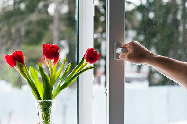 Open window with flowers in a vase