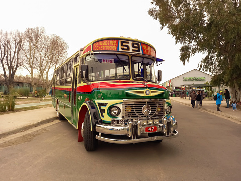 Avellaneda, Argentina - Aug 20, 2023: Old green 1980s Mercedes Benz 1114 bus in the street. Public passenger transport in Buenos Aires. Line 59. Traditional fileteado ornaments.