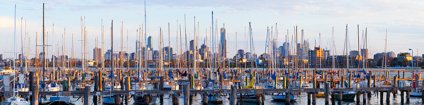 Wide angle panoramic view of the city of Melbourne through the boat masts at St Kilda in the morning light.