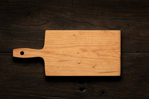 istock Handmade cherry wood cutting board on black solid wood table top. Empty wooden chopping board background. wooden cutting board. 1647653386