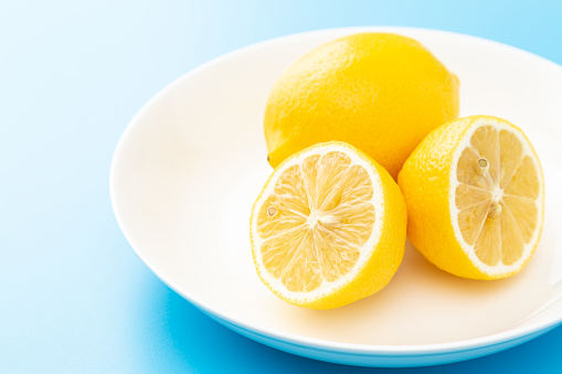 Fresh lemons on blue background.