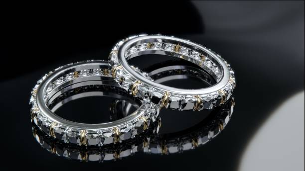 istock Two platinum diamond rings with diamonds surrounding the ring. Ring design on glossy black glass surface with 3D render. 1647669796