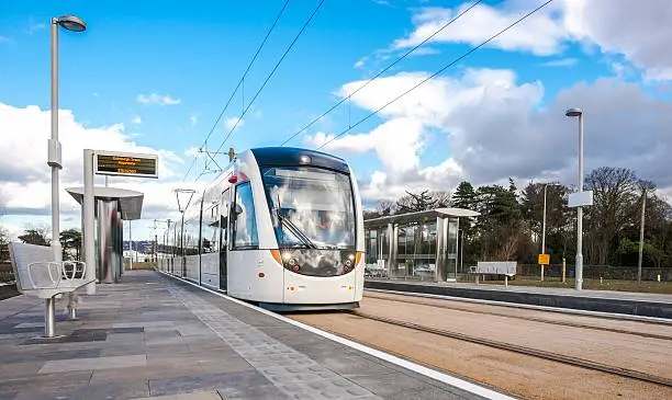 One of Edinburgh's smart new trams made by Spanish company CAF passes through Gogarburn station just by the Royal Bank of Scotland Headquarters.