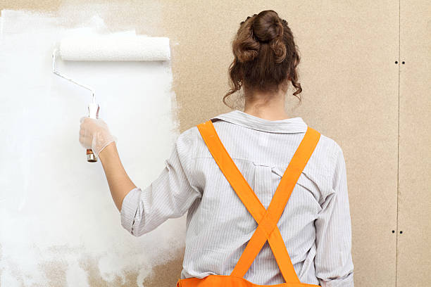 istock Female decorator painting with a paint roller 164773083