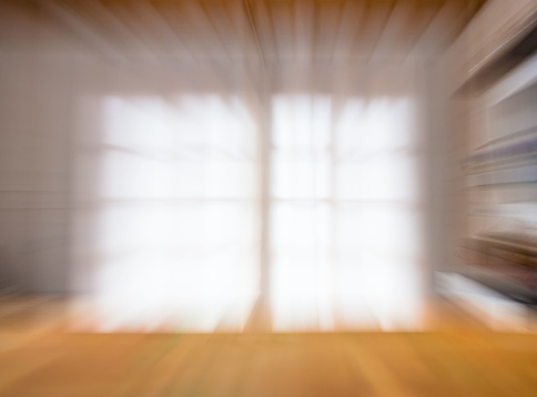 A window with a sheer white curtain out of focus, creating an abstract soft background