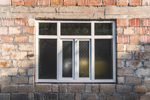 Old stone wall with window and grille