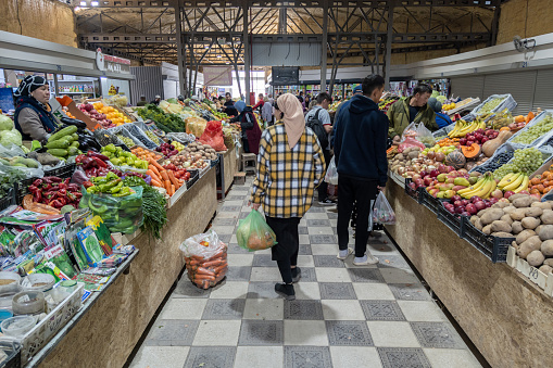 asian food market under roof with fresh vegetables and some clients in Sokuluk, Kyrgyzstan at October 1, 2022
