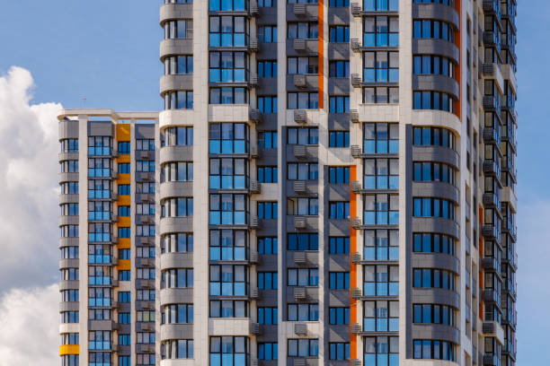 istock freshly built high rise apartment buildings on blue sky background with white clouds 1647758925