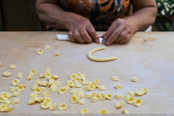 Unrecognizable person making orecchiette, typical pasta from Bari, in southern Italy stock photo