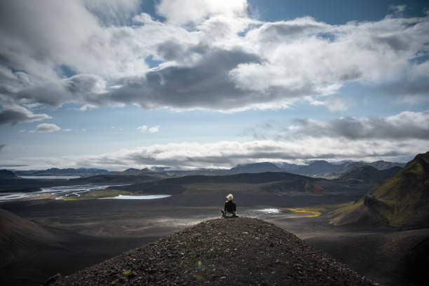 Woman sitting on top of Blahylur crater lake and enjoying the view.