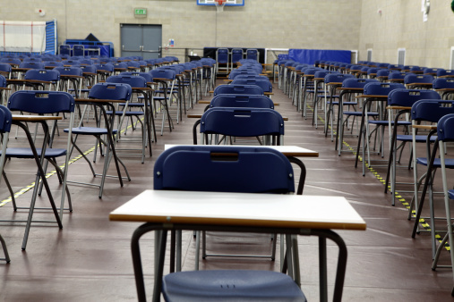 Empty examination desks and chairs in a high school exam hall.