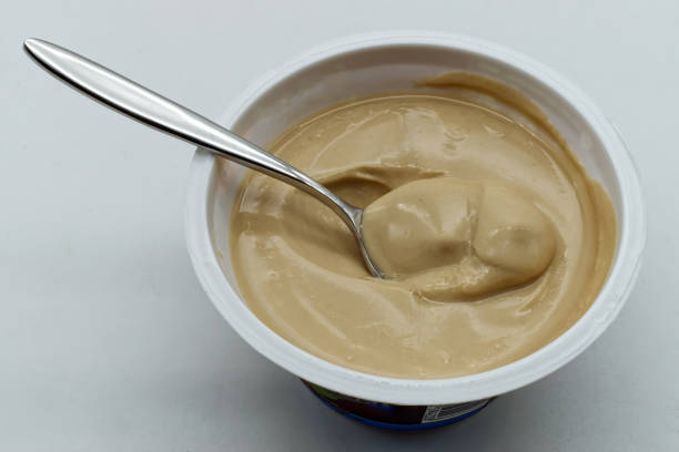 istock Coffee yoghurt in a plastic cup on wooden table 1647786219